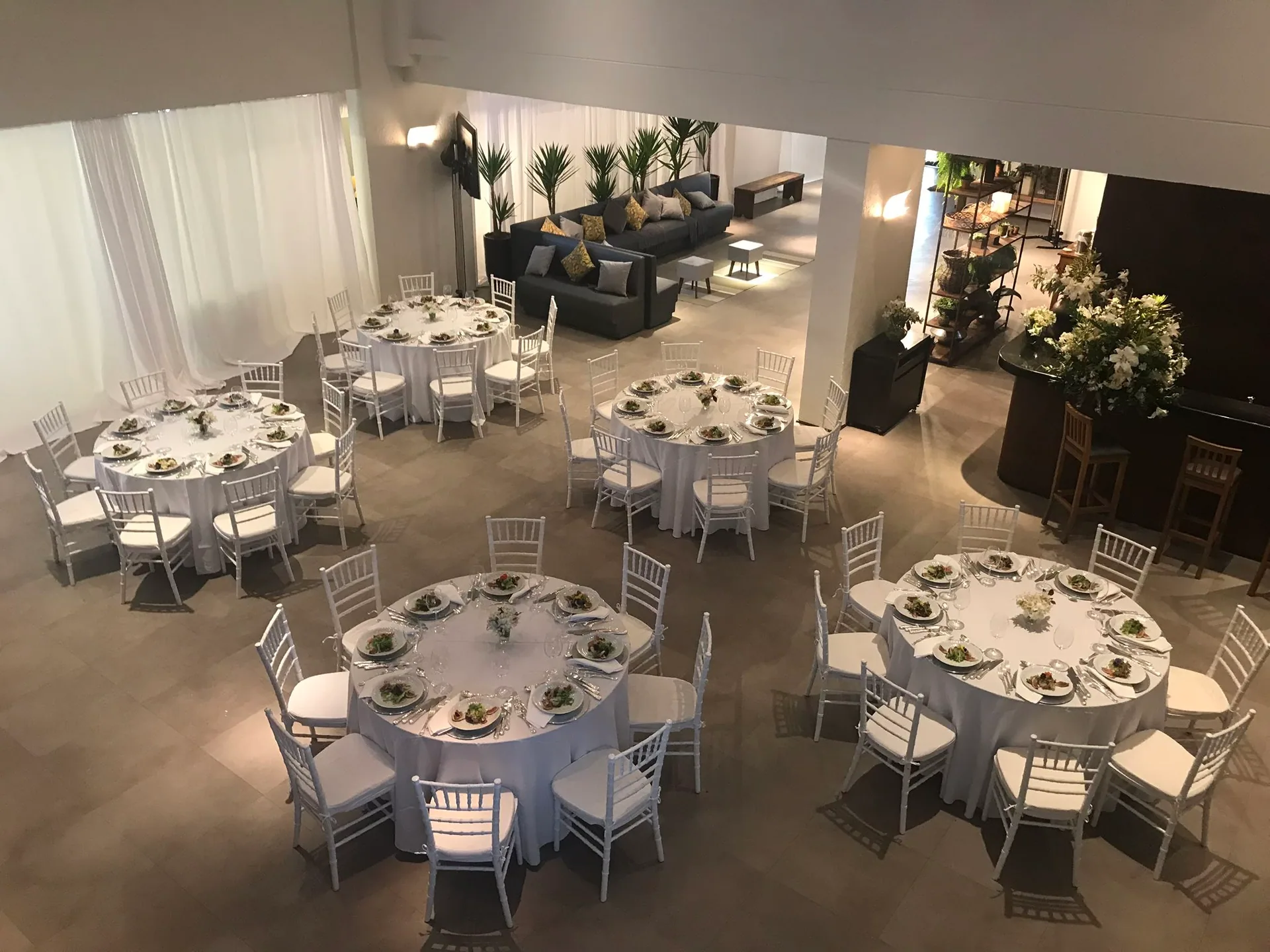 Salão montado com mesas redondas para jantar corporativo