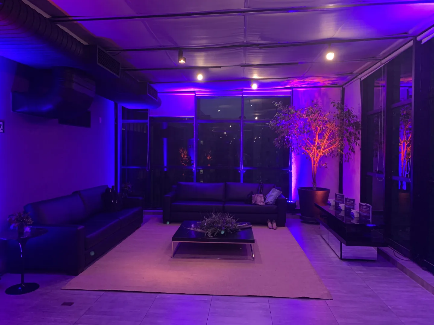Lounge do espaço com iluminação cênica em tons personalizados